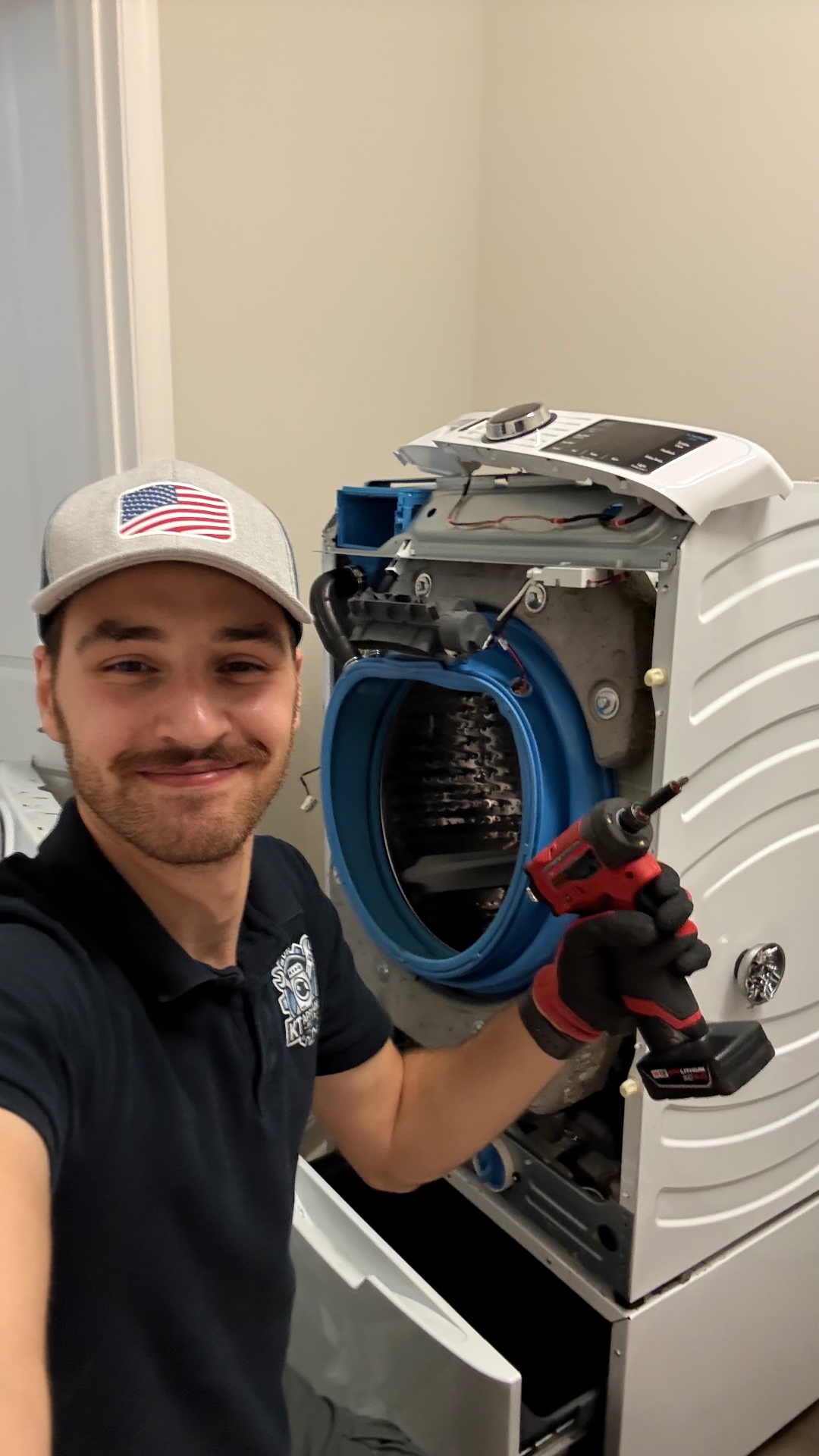 Technician with drill working on washer unit